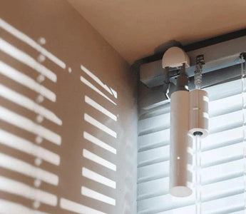 Smart WiFi motorized blinds controller installed on venetian window blinds