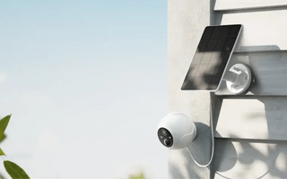 Outdoor WiFi smart camera with solar panel mounted on house wall for home security