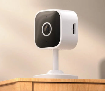 WiFi smart home security camera on a wooden table, modern indoor surveillance device