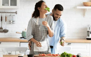 Couple cooking fresh vegetables in modern kitchen, enjoying healthy meal together