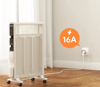 White space heater with 16A power rating, plugged into wall socket on wooden floor near window