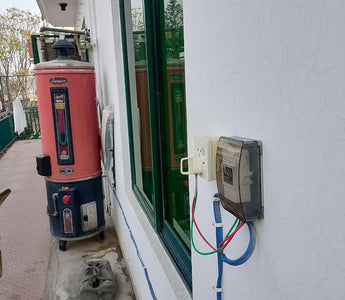 Outdoor electric geyser switch installation with smart wiring on building exterior wall