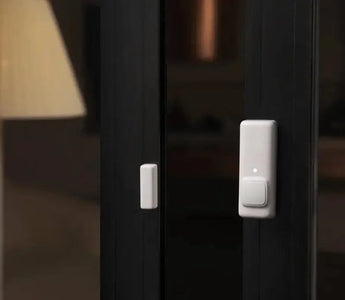 Smart contact sensor installed on a glass door for home security automation