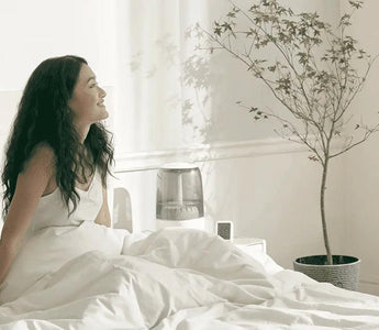 Woman relaxing in smart bedroom with humidifier and plant, enjoying modern home comfort